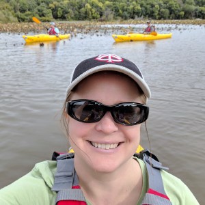 Selfie taken from a kayak, with two kayakers in the background.